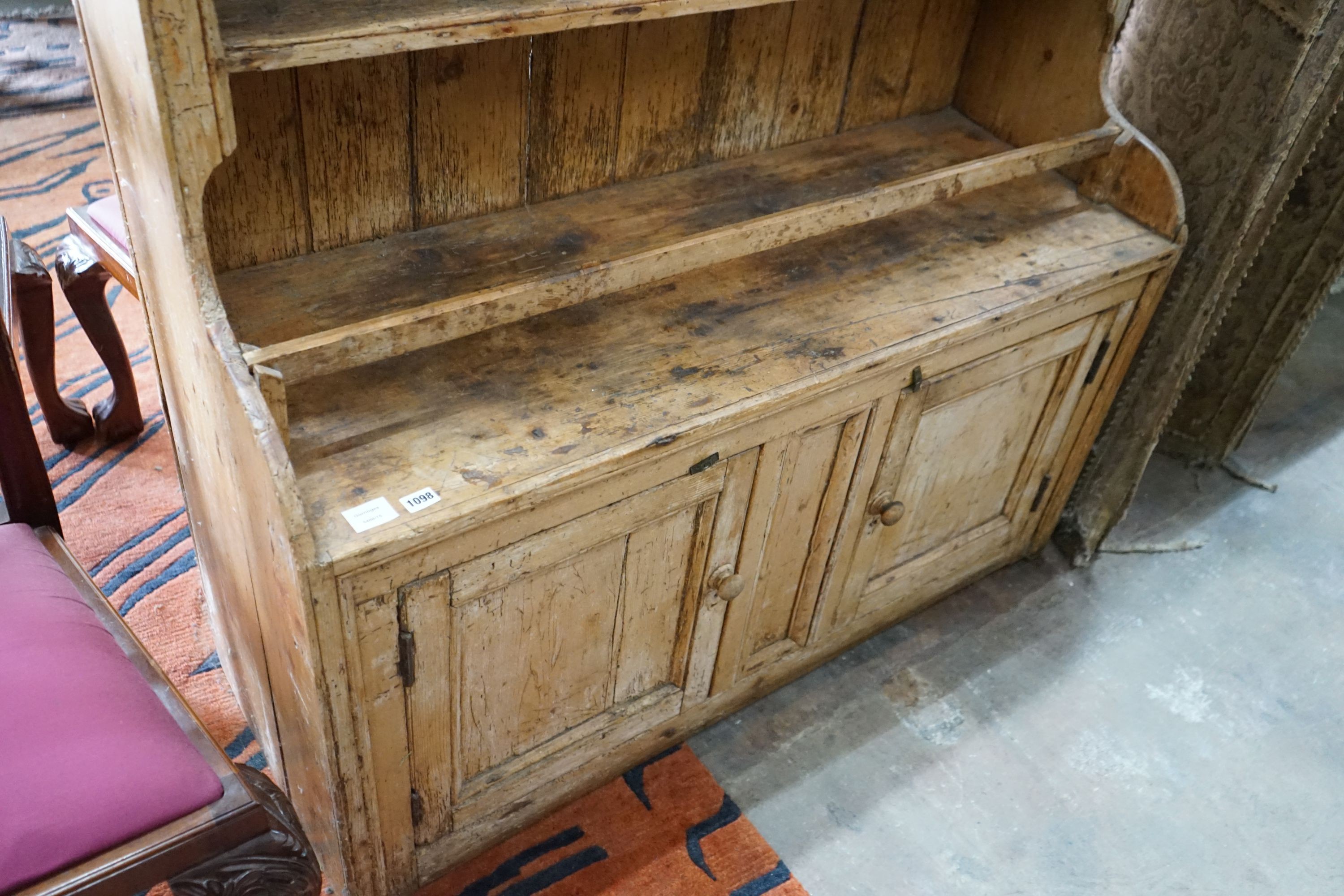 An early 19th century Irish pine dresser with boarded rack, length 129cm, depth 49cm, height 185cm